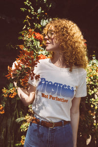 Women stood in front of a flowering bush wearing Progress Not Perfection Fitted Crewneck by The Bee and The Fox