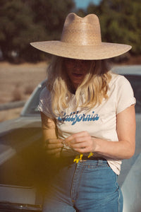Woman leaning on a car wearing California Ringer Tee for Women by The Bee and The Fox