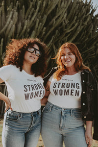 Two women outside wearing Here's to Strong Women Shirt by The Bee and The Fox