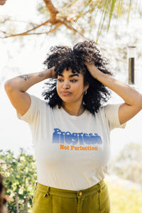 Woman stood outside with her hands in her hair wearing Progress Not Perfection Fitted Crewneck by The Bee and The Fox