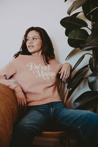 Woman sat on wooden chair wearing Proud Mama Cropped Sweatshirt by The Bee and The Fox