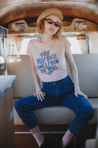 Woman sat in campervan wearing Peach The Best Buzz Comes from the Bees Shirt by The Bee and The Fox